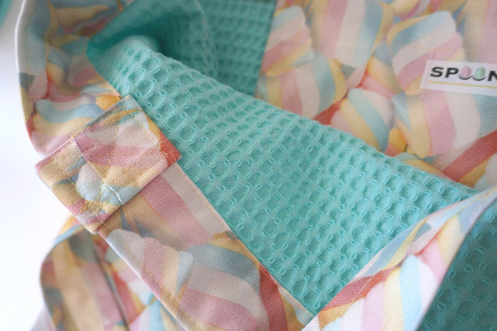 Close-up of a textured pastel blue waffle cotton with colorful marshmallow  patterned fabric background