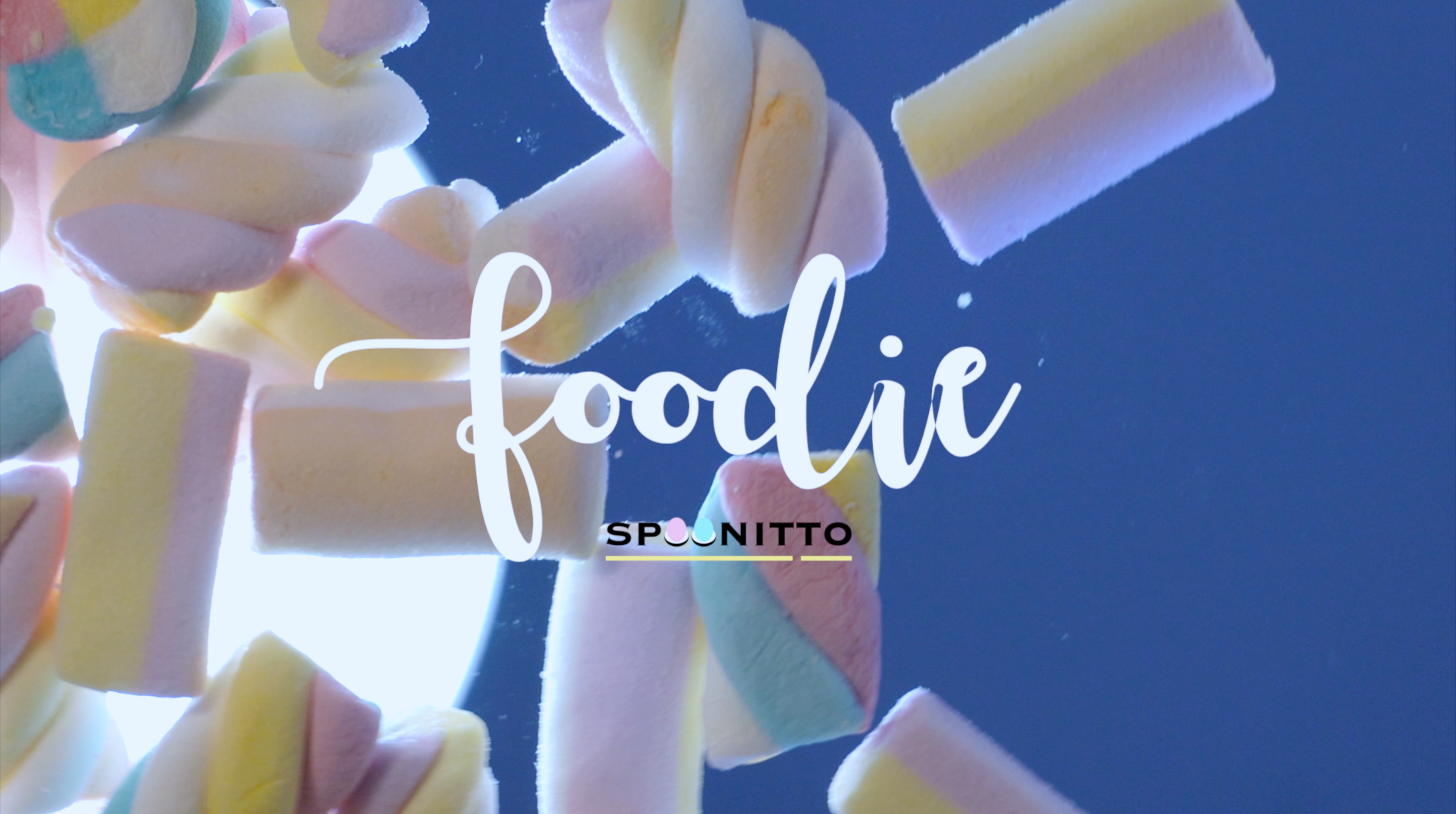 Colorful marshmallows with 'foodie' text and 'SPOONITTO' brand on a blue background