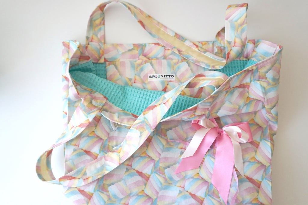 Colorful tote bag with a marshmallow pattern and a pink ribbon bow on a white background