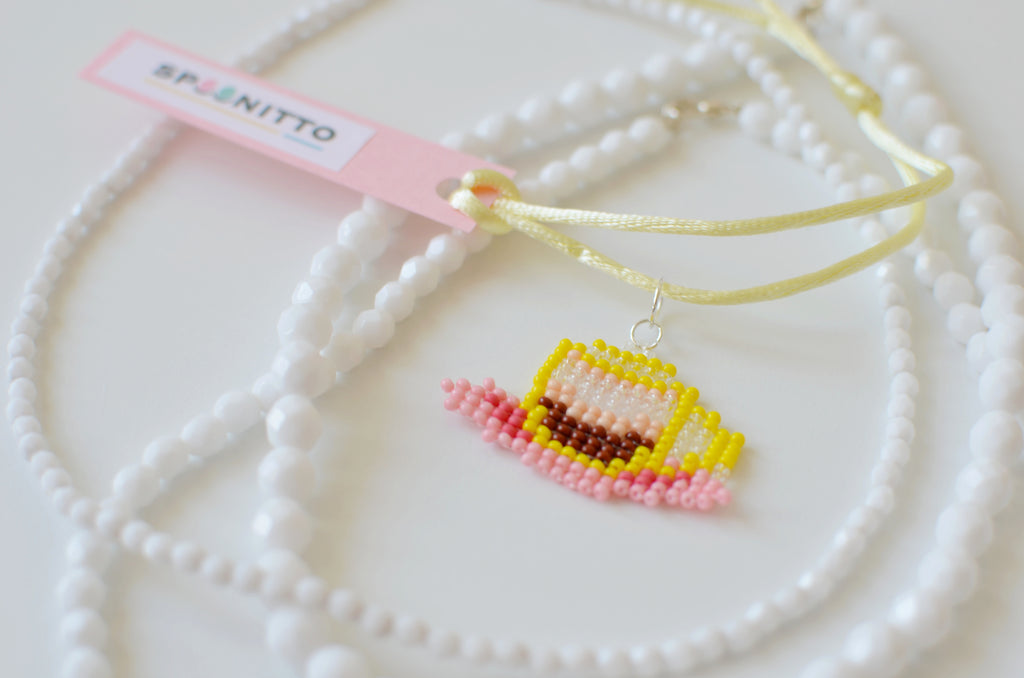 Handmade beaded Italian coffee necklace with a SPOONITTO brand card on a white background.