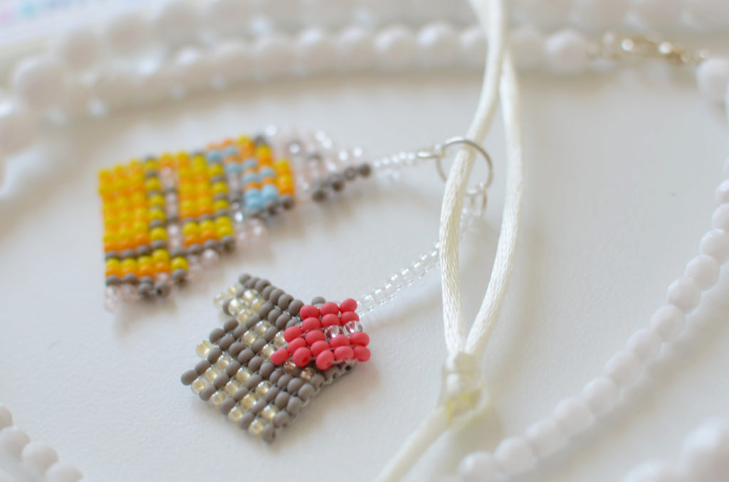 Handmade beaded Colosseum necklace on a white background.