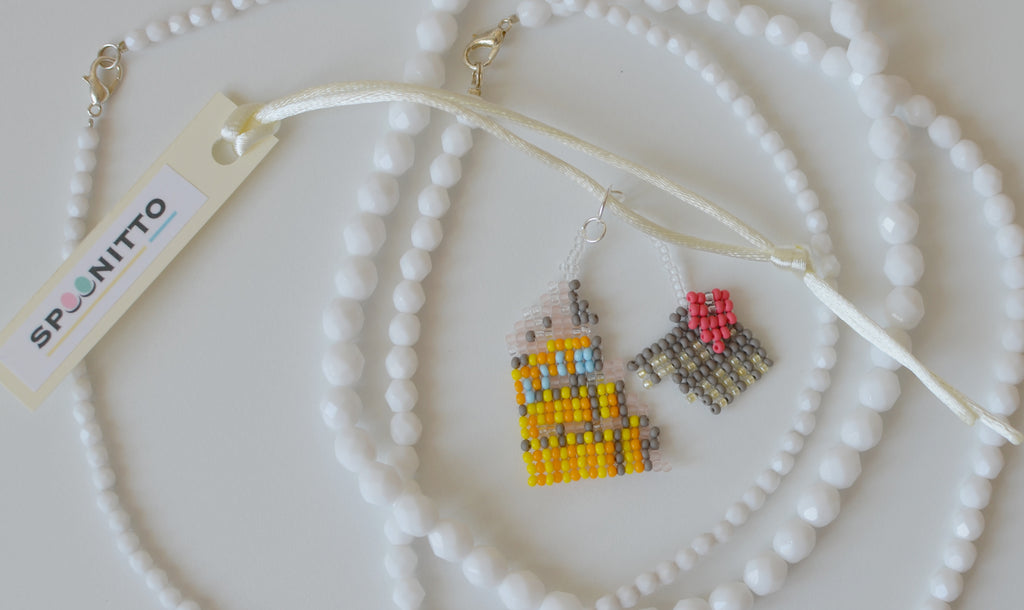 Close-up of a beaded Roman Colosseum pendant on a white background.