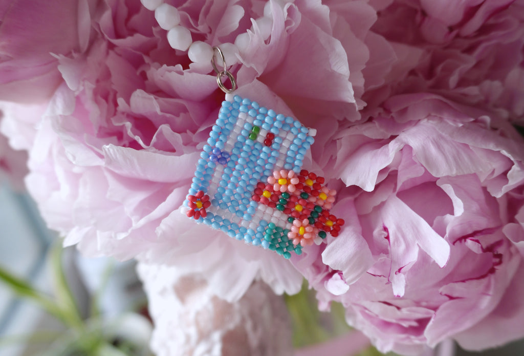 beaded necklace with Italian front door and geraniums with pink peony background