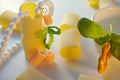 Hand-made beaded necklace inspired by Italian food with paccheri pasta and basil as a background