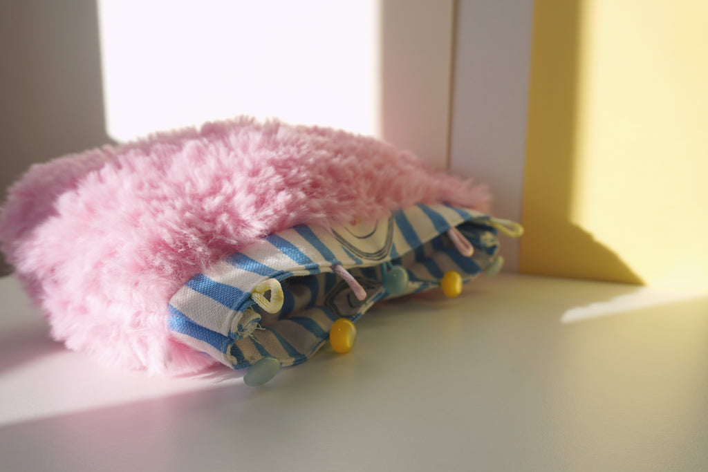 Pink fluffy small bag on a light surface 