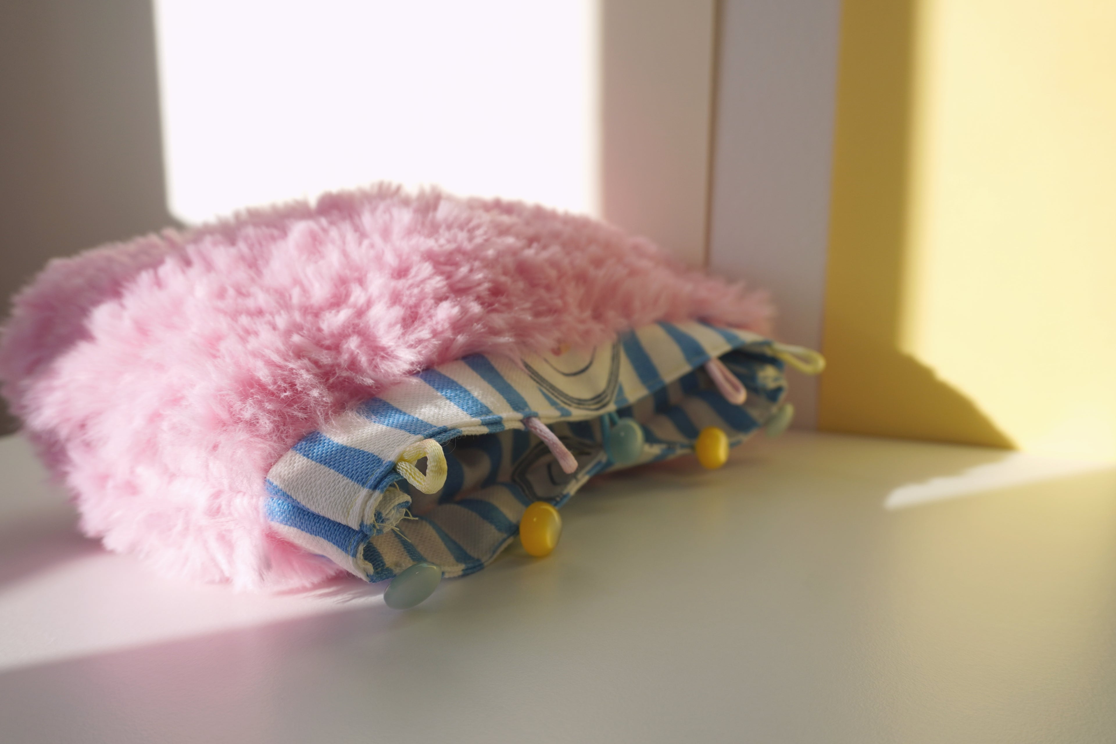 Pink fluffy small bag on a light surface 
