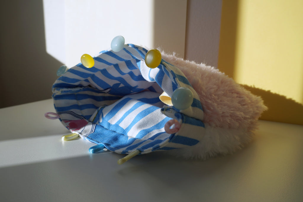 Small hand-sewn and hand-knitted purse with blue and white striped lining on a light surface - SPOONITTO brand
