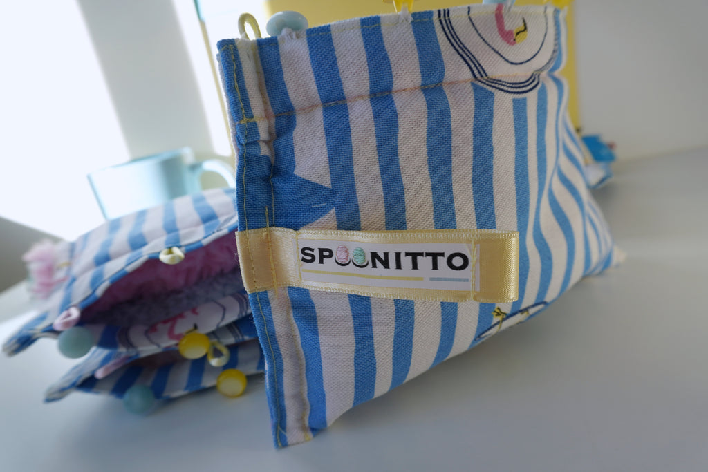 Blue and white striped purses with 'Spoonitto' label on a light surface