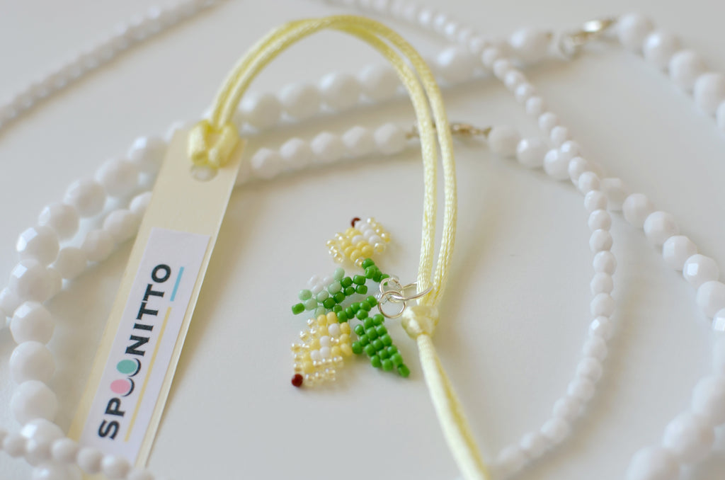 Necklace with a lemon pendant and SPOONITTO brand card on a white background